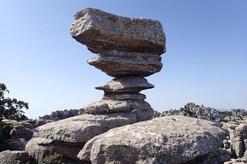 A large balanced rock formation in a natural landscape. 3