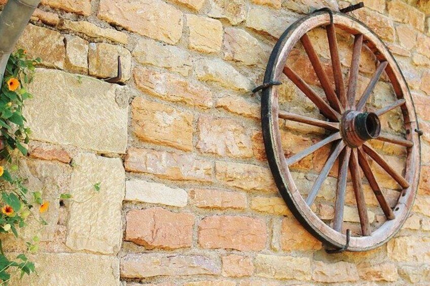 Un mur de pierres sur lequel est fixée une vieille roue en bois. 5