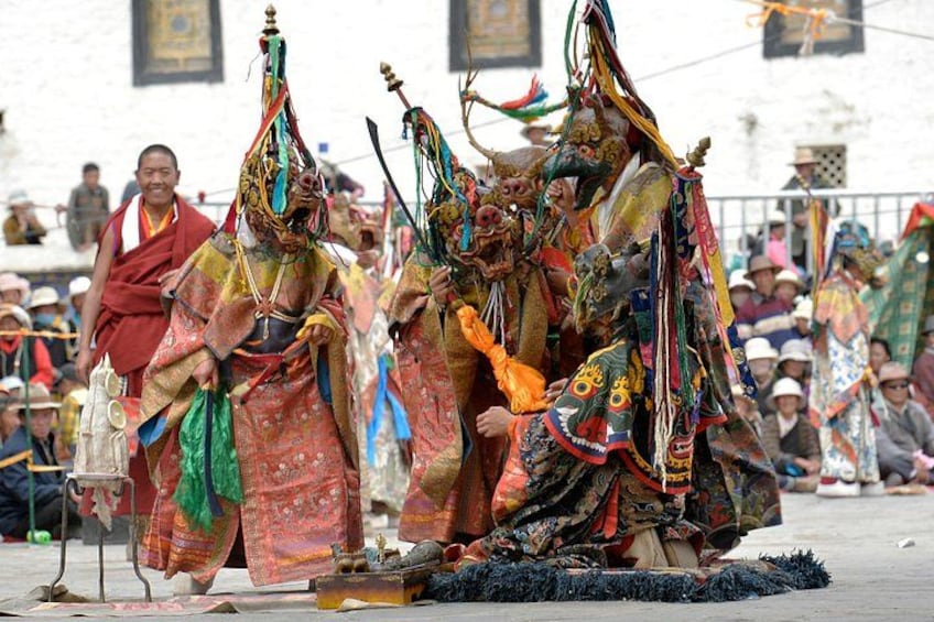 Un gruppo di persone in abiti tradizionali colorati, forse durante un rito o una cerimonia. 1