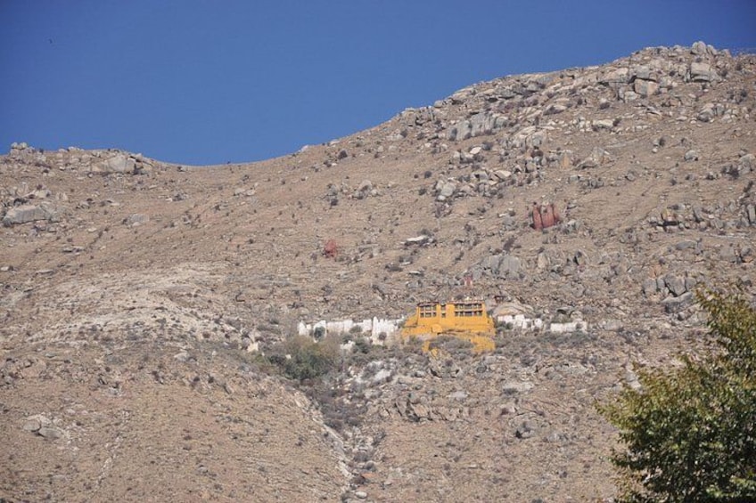 Un pendio roccioso con un edificio giallo e una costruzione bianca. 5