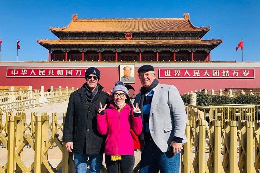 A group of people in front of a traditional Chinese building with red walls and golden roof. 5