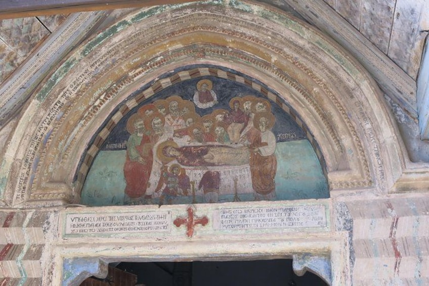 A fresco with a religious scene, a cross, and inscriptions. 2