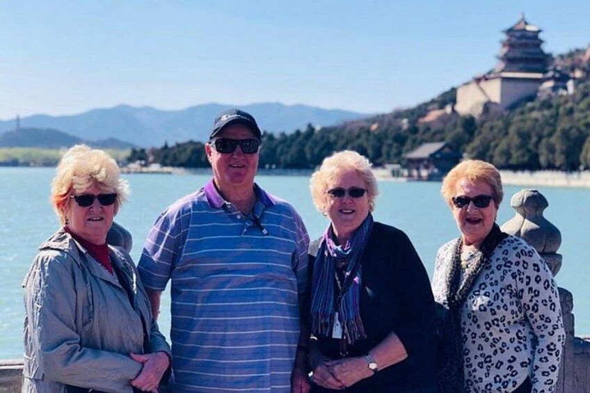 Un grupo de personas de pie junto a un lago, con una pagoda al fondo. 4
