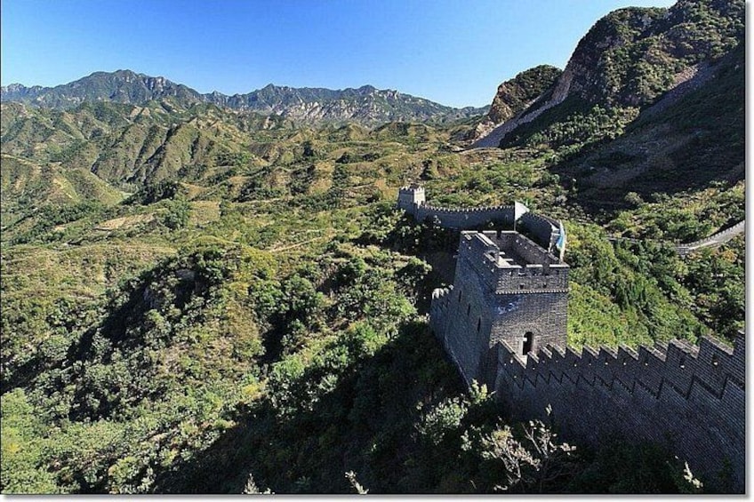 A mountainous landscape with a stone wall structure. 1