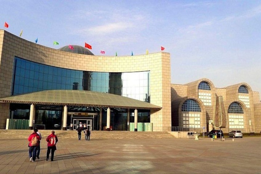 A large, modern building with a curved facade, large glass windows, and a prominent entrance. 2