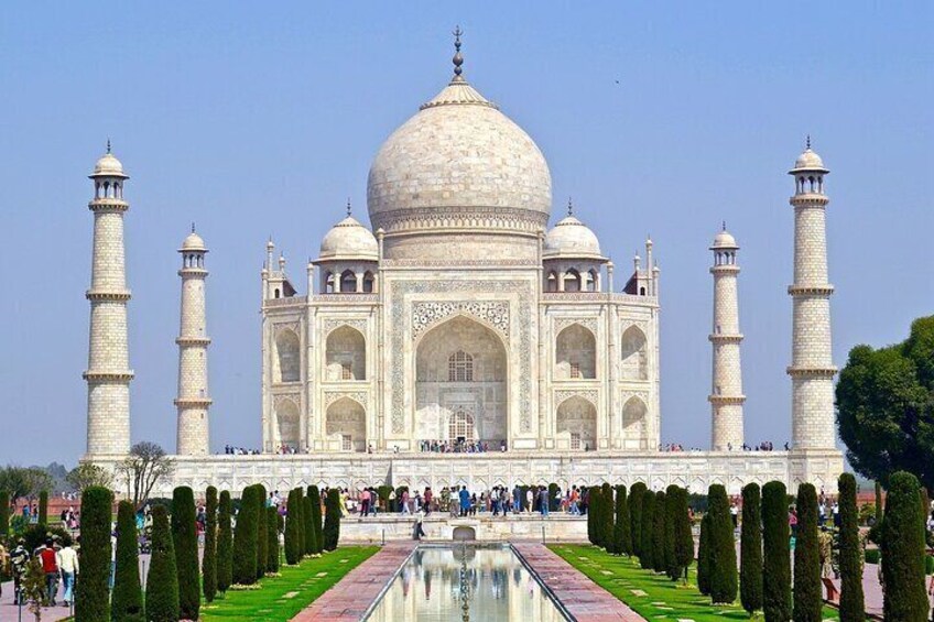 The Taj Mahal with its four minarets and central dome, surrounded by a formal garden with a reflecting pool. 3