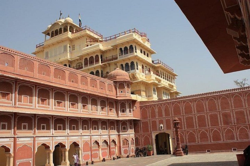 A large, multi-tiered building with arched windows and a red facade. 5