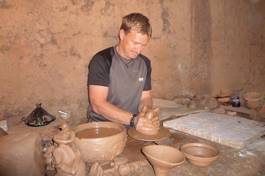 A person working with clay pottery in a workshop. 4