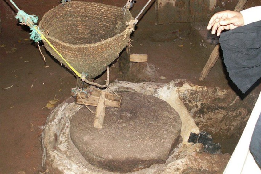 A traditional cooking setup with a woven basket and a stone stove. 3