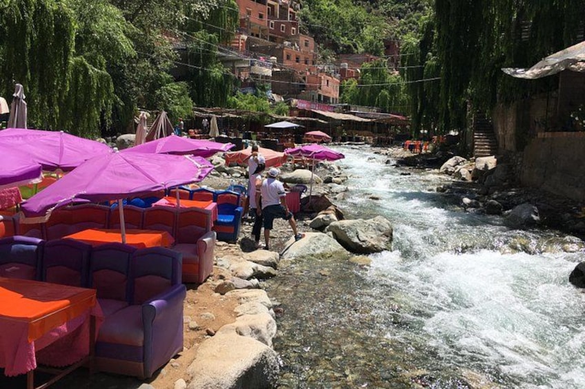 A river with rocks, colorful chairs, and umbrellas. 5