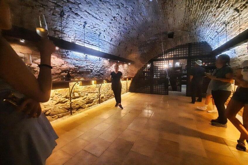 An underground wine cellar with stone walls and a wooden structure. 5