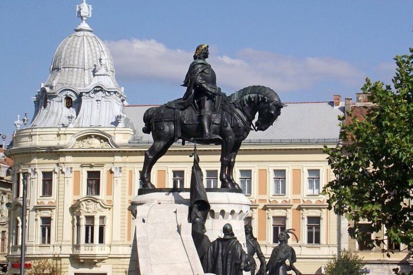 Eine Statue eines Mannes zu Pferd vor einem Gebäude mit einer Kuppel. 1