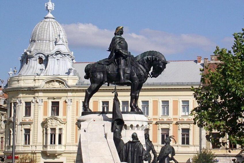 Una estatua de un hombre a caballo frente a un edificio clásico con cúpula. 1