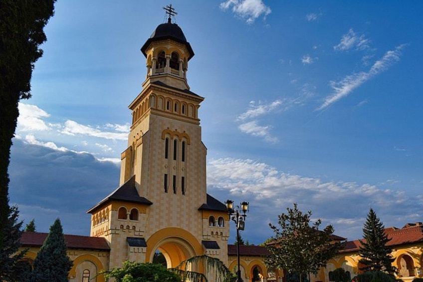A church with a tall bell tower, arched windows, and a red roof. 2