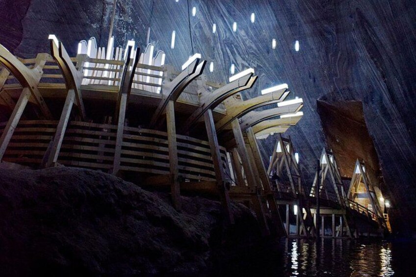 Una estructura arquitectónica moderna con elementos iluminados, frente a un paisaje rocoso. 1