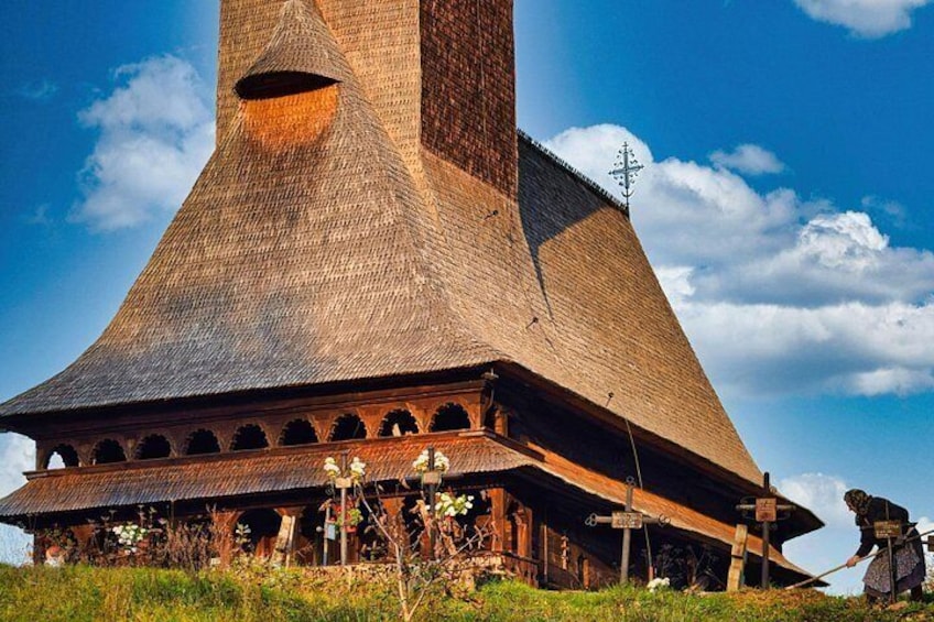 Un grand bâtiment conique, surmonté d’un toit pointu et entouré de verdure. 1