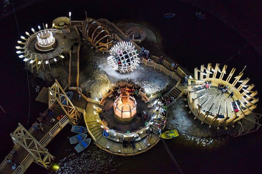 Ein großer, beleuchteter Vergnügungspark mit einem zentralen Riesenrad, einem kleineren Riesenrad und einer Karussellfahrt. 2