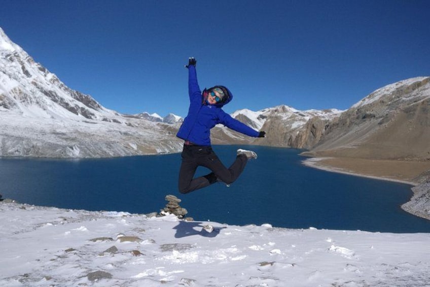 A person jumping in mid-air with a mountainous landscape and a lake in the background. 5