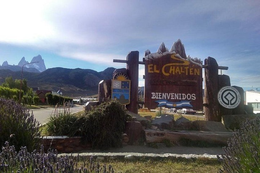 A sign with 'EL CHALTEN' and 'BIENVENIDOS' welcoming visitors, with mountains in the background. 1