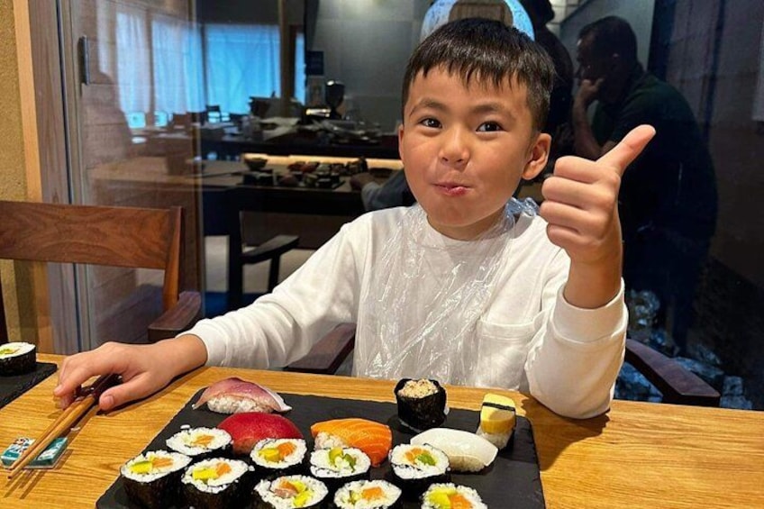Una persona seduta a un tavolo con diversi piatti di sushi. 2