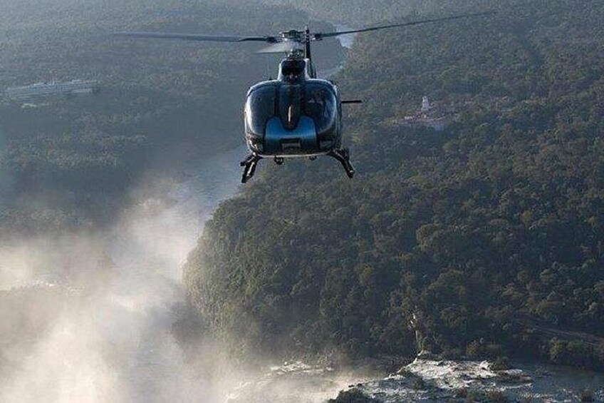 Un helicóptero volando sobre un río con un paisaje boscoso debajo. 4