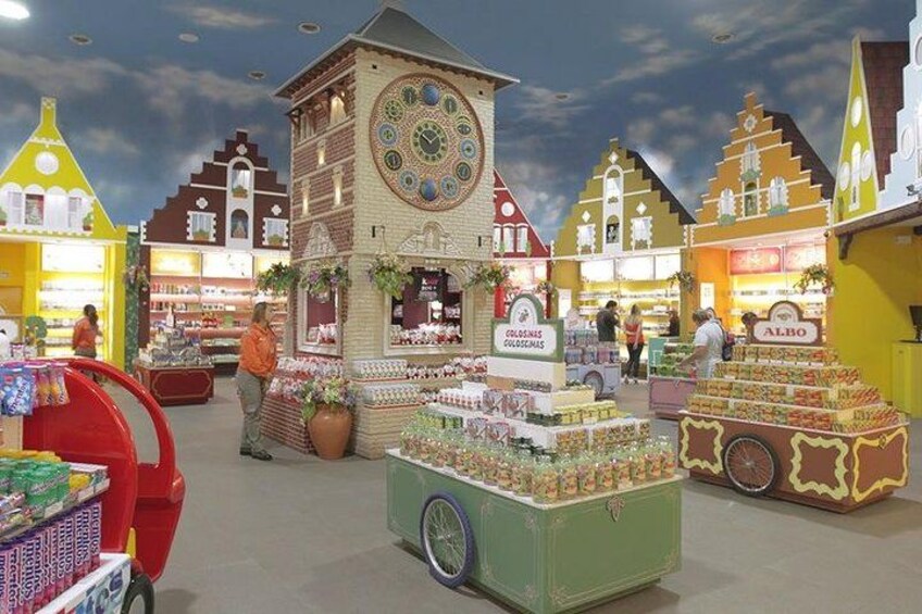 Een markt met kraampjes, een klokkentoren en diverse winkels. 2