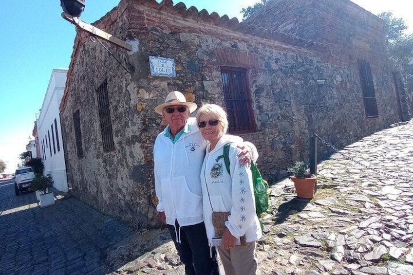 Zwei Personen stehen vor einem Steinhaus, auf dessen Schild 'Solís' steht. 5