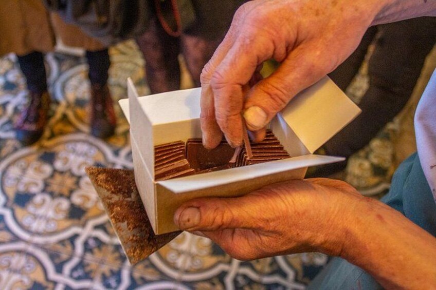 Une personne tenant une petite boîte contenant un objet en bois. 3