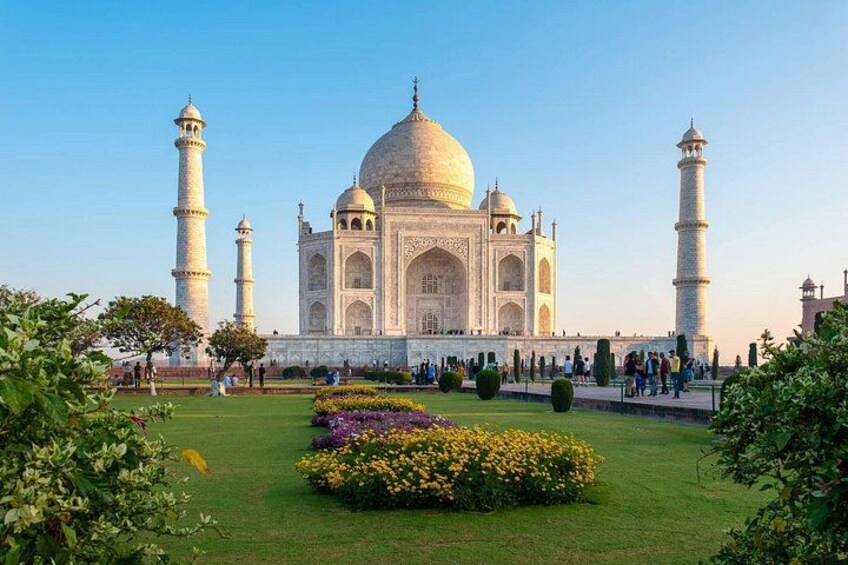 De Taj Mahal met vier minaretten, een grote centrale koepel en een goed onderhouden tuin met bloemen. 2