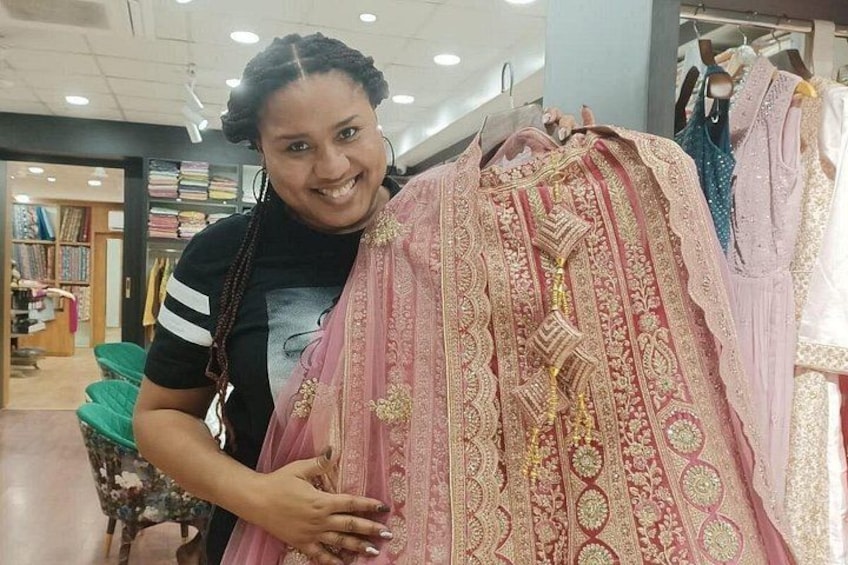 A person holding a pink traditional garment with intricate patterns. 4