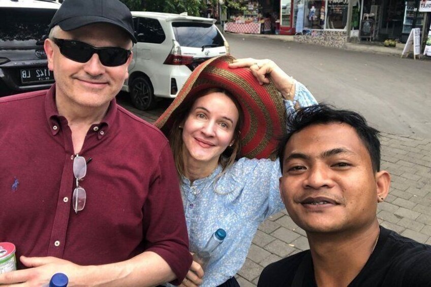 Three people outdoors, one wearing a red shirt and sunglasses, another in a blue patterned top, and a third in a black shirt. 3