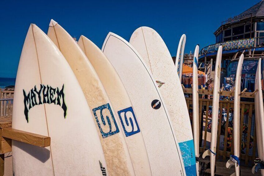 Several surfboards leaning against a wooden structure at a beachside location. 5