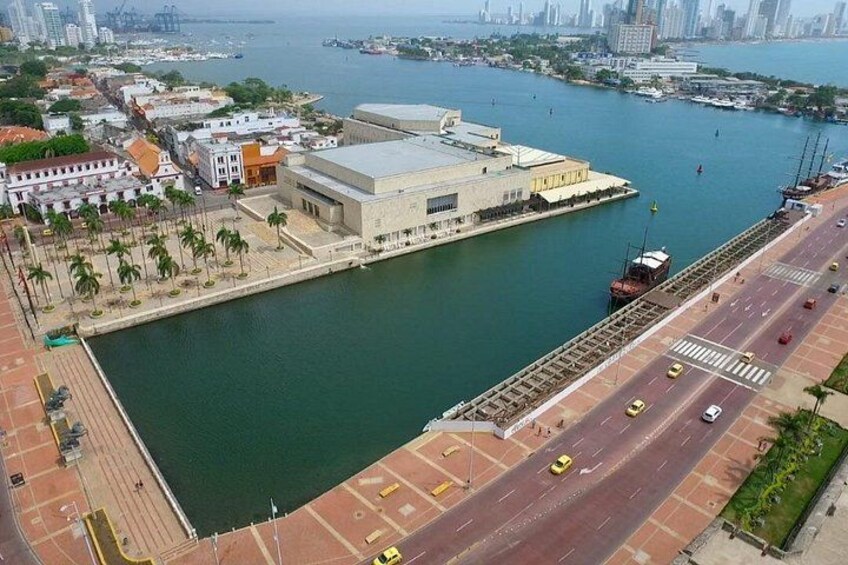 A waterfront with a bridge, buildings, and a road. 2