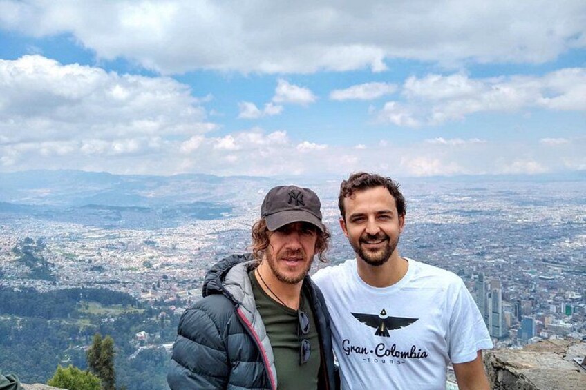 Two people standing on a high vantage point overlooking a cityscape. 3