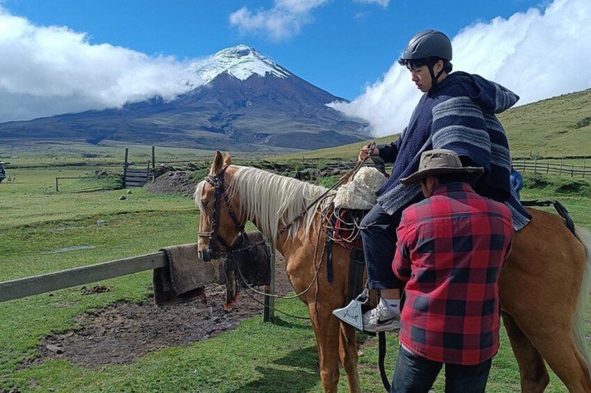 Een paard met ruiter en begeleider in een begrazend weiland, met een berg op de achtergrond. 3