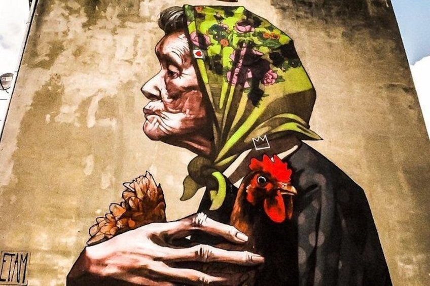 A mural of a woman with a red flower on her shoulder and a crown on her head. 1