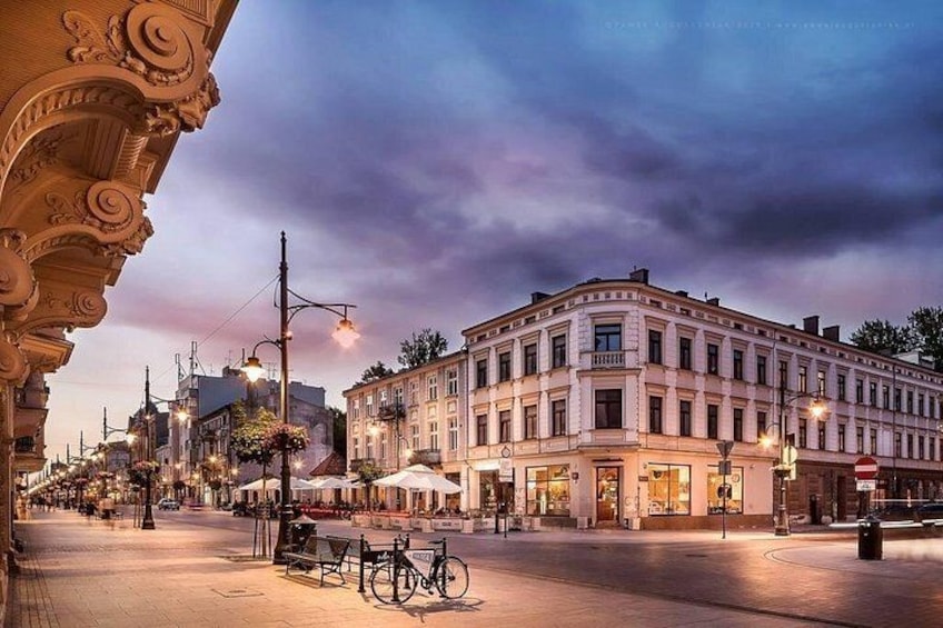 A historic building with ornate architecture, a street with a bicycle, and a café with outdoor seating. 5