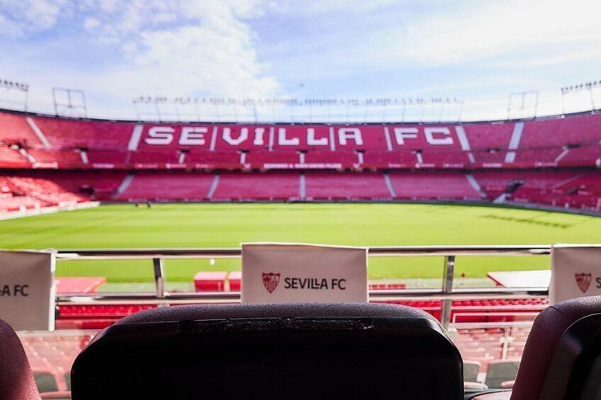 A stadium with red seating and a clear sky. 4