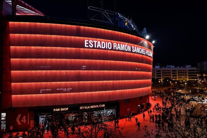 Een groot stadion met de tekst 'ESTADIO RAMÓN SANCHEZ-PLAZA' en 'SEVILLA FUTBOL CLUB' op de gevel. 2