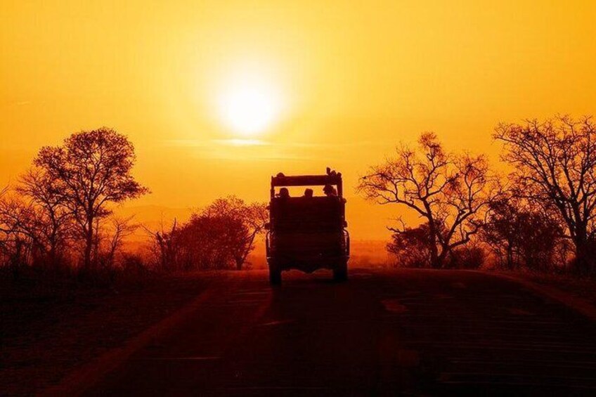 A vehicle on a road with a sunset in the background. 1