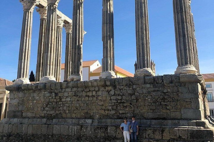 Ancient stone columns, a stone wall, and a clear blue sky. 5