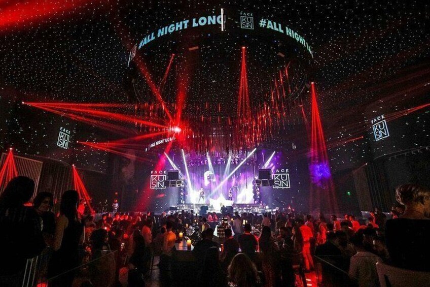 A concert with a stage, audience, and red laser lights. 1