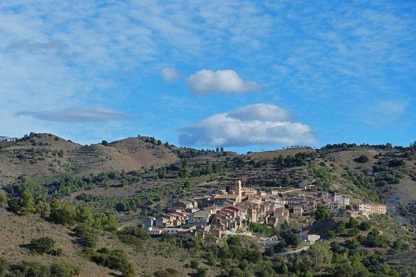 Un pueblo ubicado en un valle, con colinas onduladas al fondo. 2