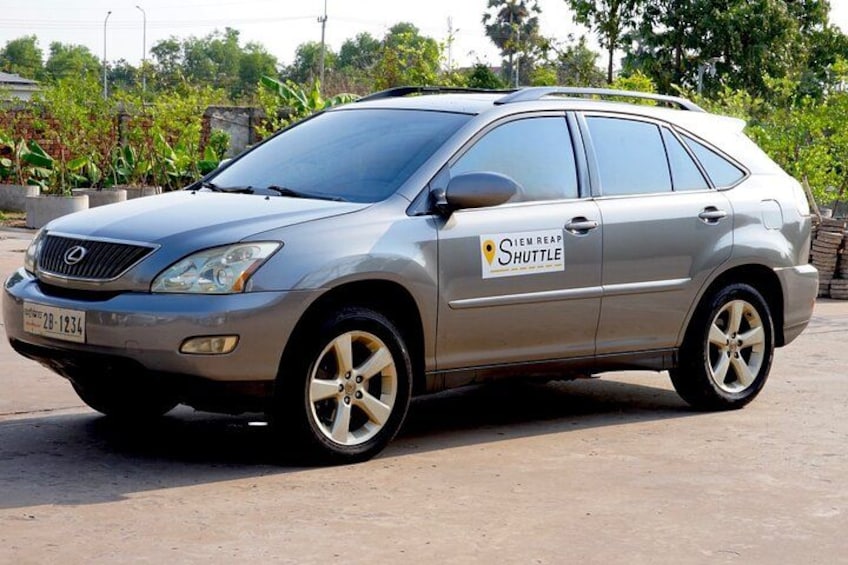 A silver Lexus SUV parked on a concrete surface with a 'Shuttle' sign on the side. 2