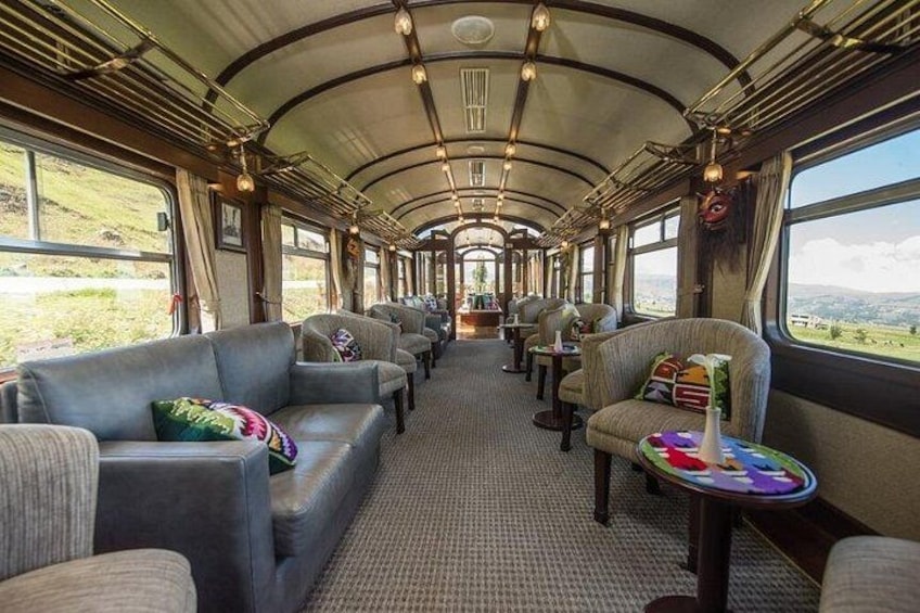 A train interior with leather seats, tables, and a carpeted floor. 3