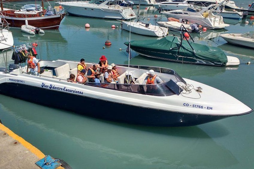 A speedboat with passengers at a marina. 5