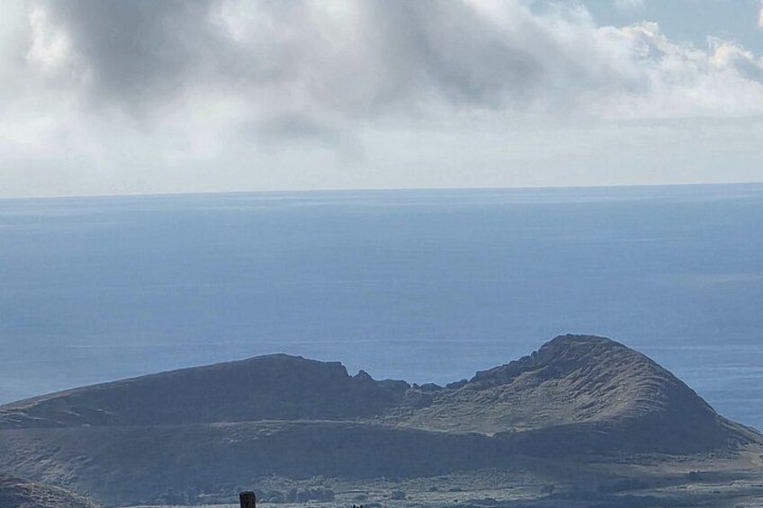 A mountain with a flat top and a cloudy sky above. 3