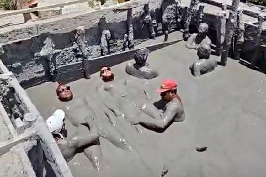 People in a water-filled area with stone sculptures. 1