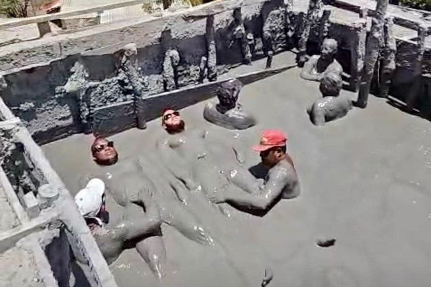 People in a water-filled area with stone structures. 3