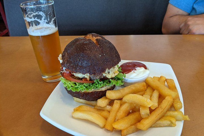 A burger with fries and a glass of beer on a plate. 2